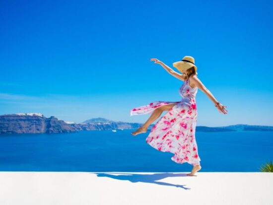 Co powoduje, że człowiek jest szczęśliwy? Na zdjęciu szczęśliwa kobieta na wakacjach.