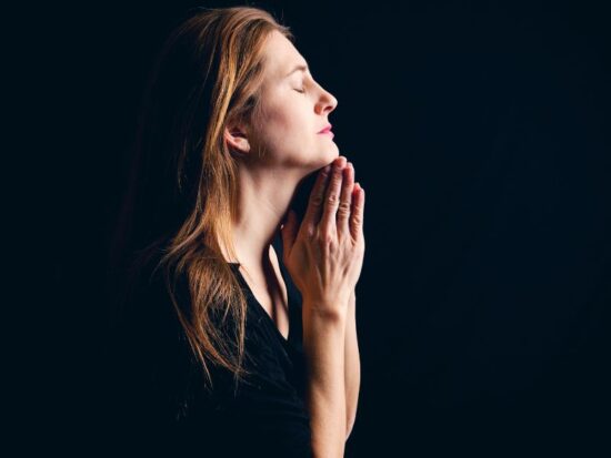 Wiara protestancka a wiara katolicka. Na zdjęciu kobieta podczas modlitwy.