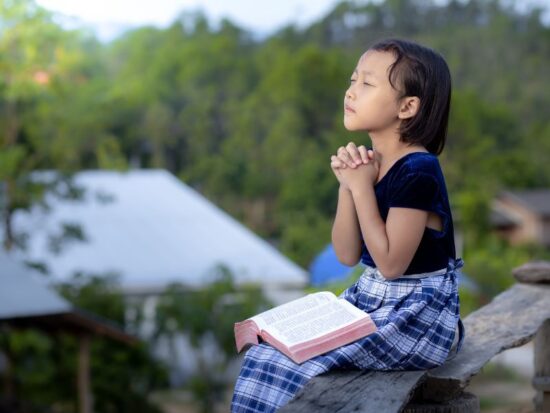 Definicja wiary – jak ją dziś określić? Na zdjęciu dziewczynka podczas modlitwy.